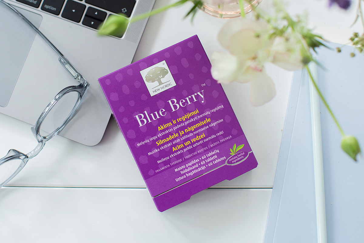 Blue Berry™ Gummies 13 New Nordic Blue Berry™ maisto papildas akims ir regėjimui, šalia akinių ir gėlių.