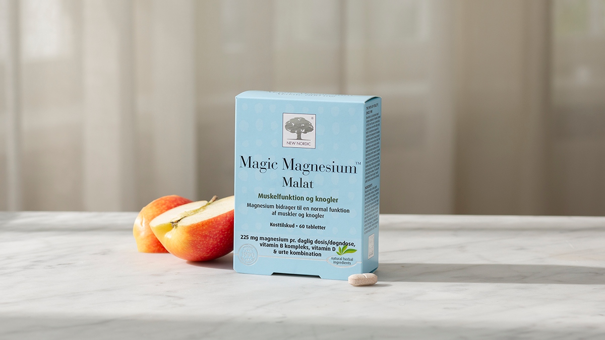 Magnio malatas – kaip jis naudingas jūsų raumenims 23 „New Nordic Magic“ magnio malato pakuotė su obuoliais ir tabletėmis šviesaus fono fone.