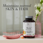 „Biotin™ Gummies“ pakuotė su rožine plaukų šepečiu ir užrašu apie odos bei plaukų priežiūrą.