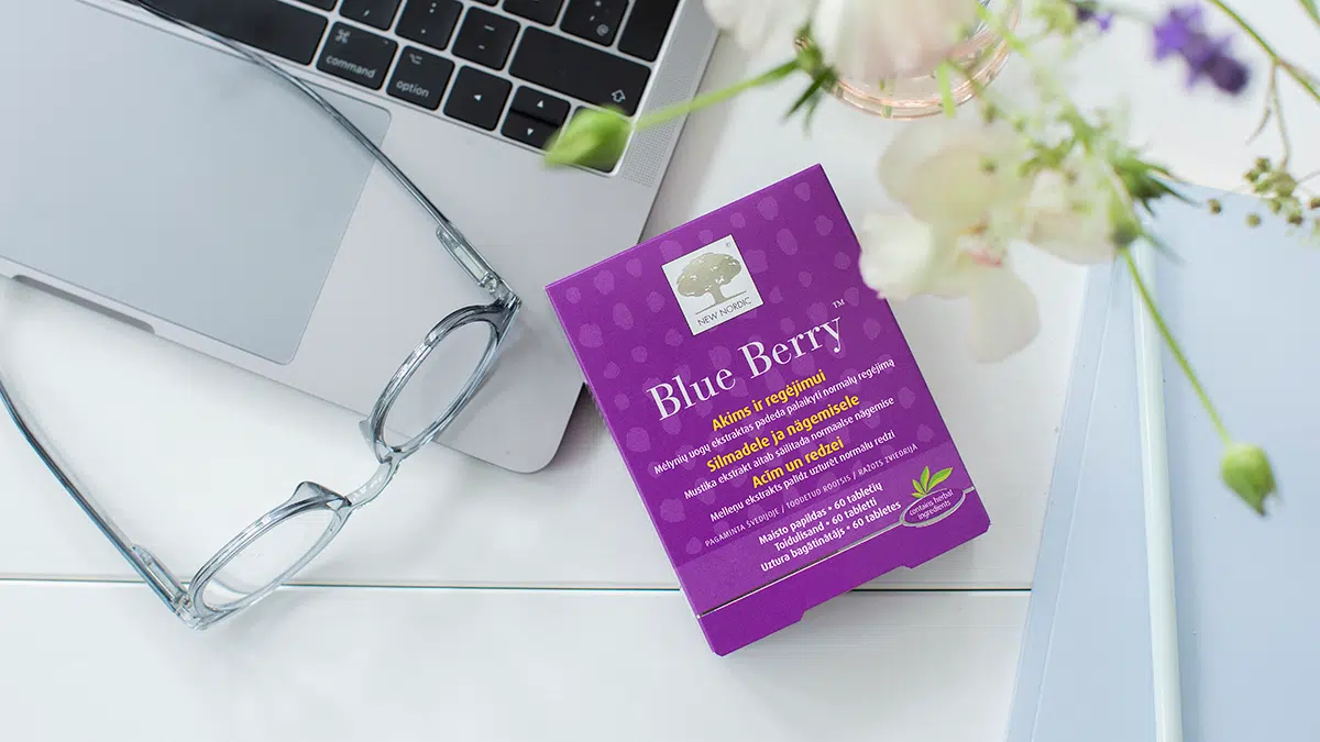 „Blue Berry™“ tablečių pakuotė ant stalo šalia nešiojamojo kompiuterio ir akinių.
